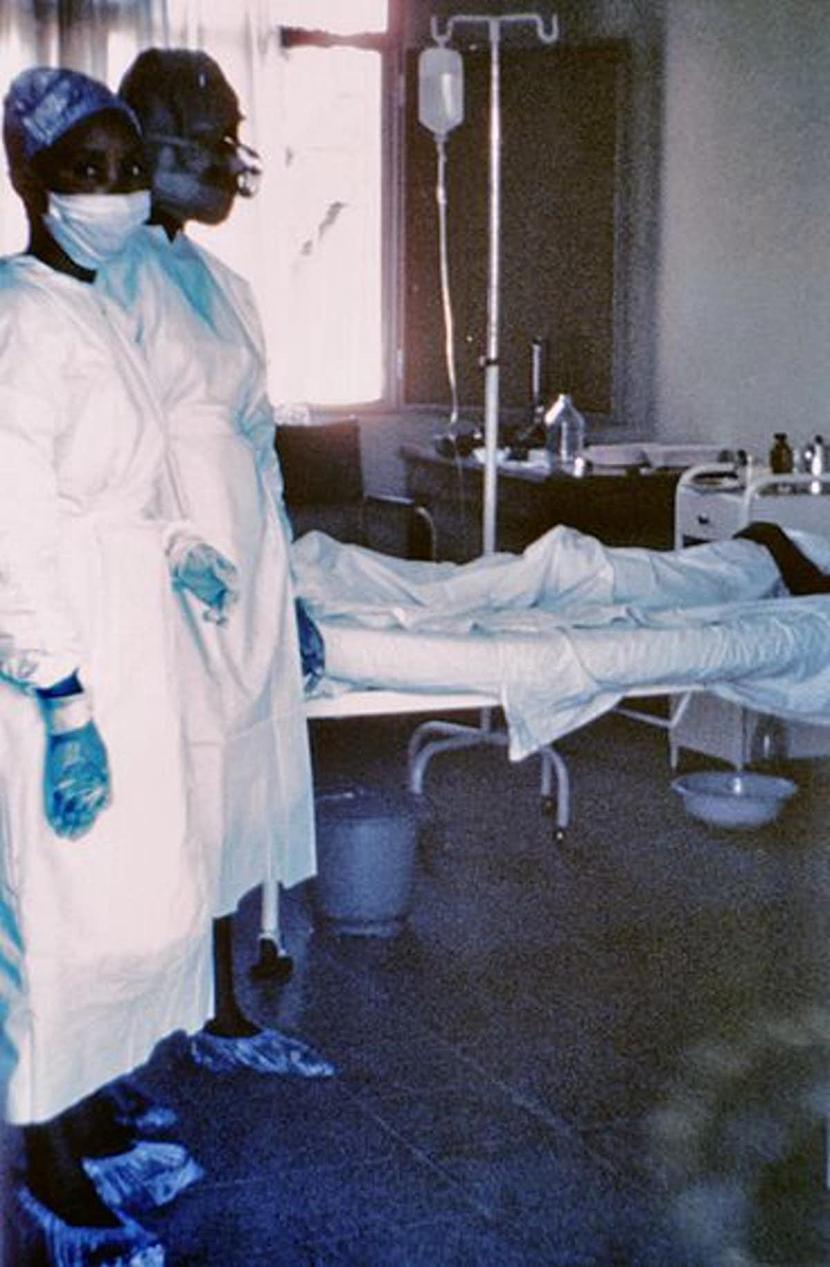 Две медсестры около кровати с больным лихорадкой Эбола