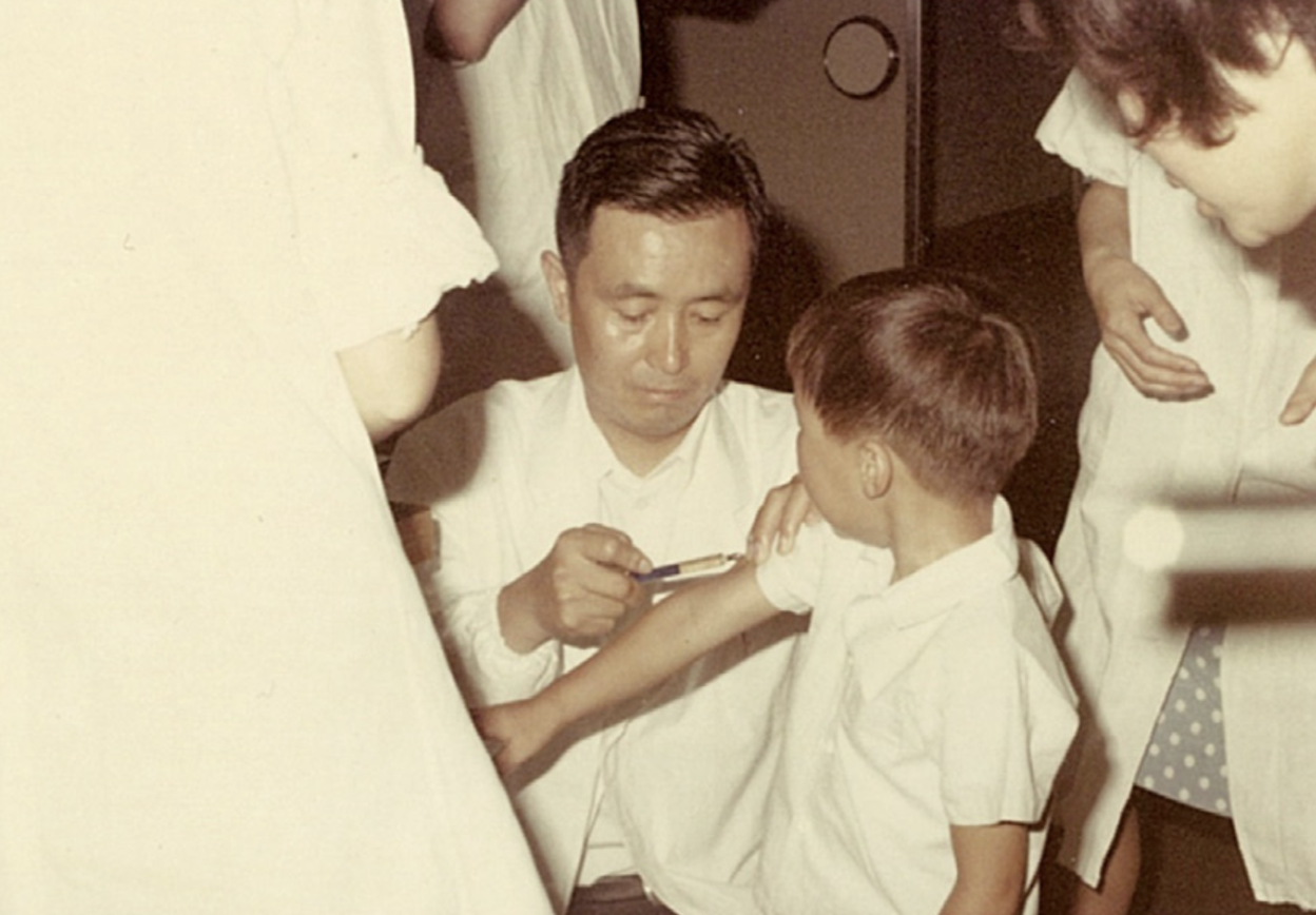 Доктор Митиаки Такахаси делает прививку от ветряной оспы ребенку-добровольцу